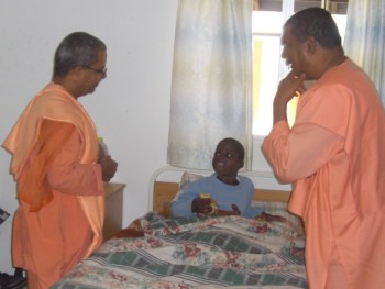 The visiting Swami Virabhadanndaji with Swami Saradaprabhanandaji at Abandi Home talking to a terminally ill patient